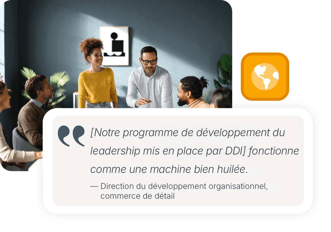 A group of colleagues collaborating around a table with laptops, notebooks, and mugs.